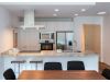 Optima Verdana luxury apartment with Modern kitchen in Optima Verdana one-bedroom residences, featuring light wood cabinets, stainless steel appliances, and a marble island.