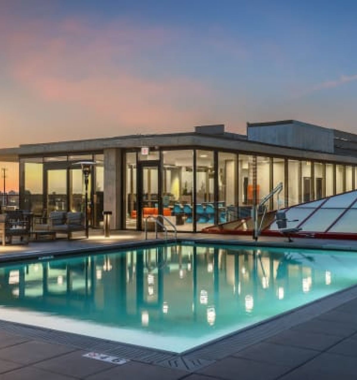 Optima Verdana luxury apartment with Rooftop pool and lounge area at sunset with city skyline views, perfect for alfresco cooking at Optima Communities.