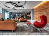 Optima Verdana luxury apartment with Modern lounge area at Optima Verdana with leather sofas, a red chair, and a glass wall showing the gym—built to last for years.