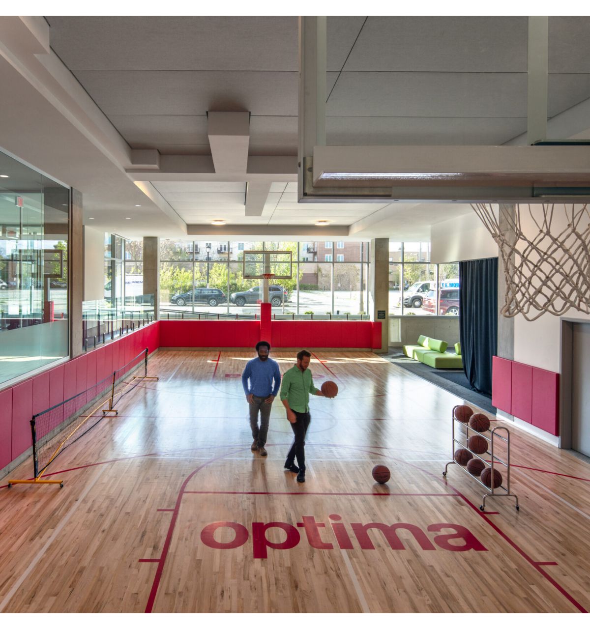 Optima Verdana luxury apartment with Two people walk on an indoor basketball court with "optima" written on the floor, enjoying daily life in the Optima Community.