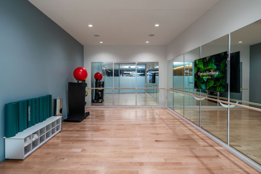 Optima Verdana luxury apartment with Spacious ballet studio with wooden floors, wall mirrors, ballet barre, exercise mats, and red exercise balls.