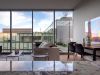 Optima Verdana luxury apartment with Modern living room with floor-to-ceiling windows overlooking a building exterior, perfect for small rituals in an Optima Verdana setting.