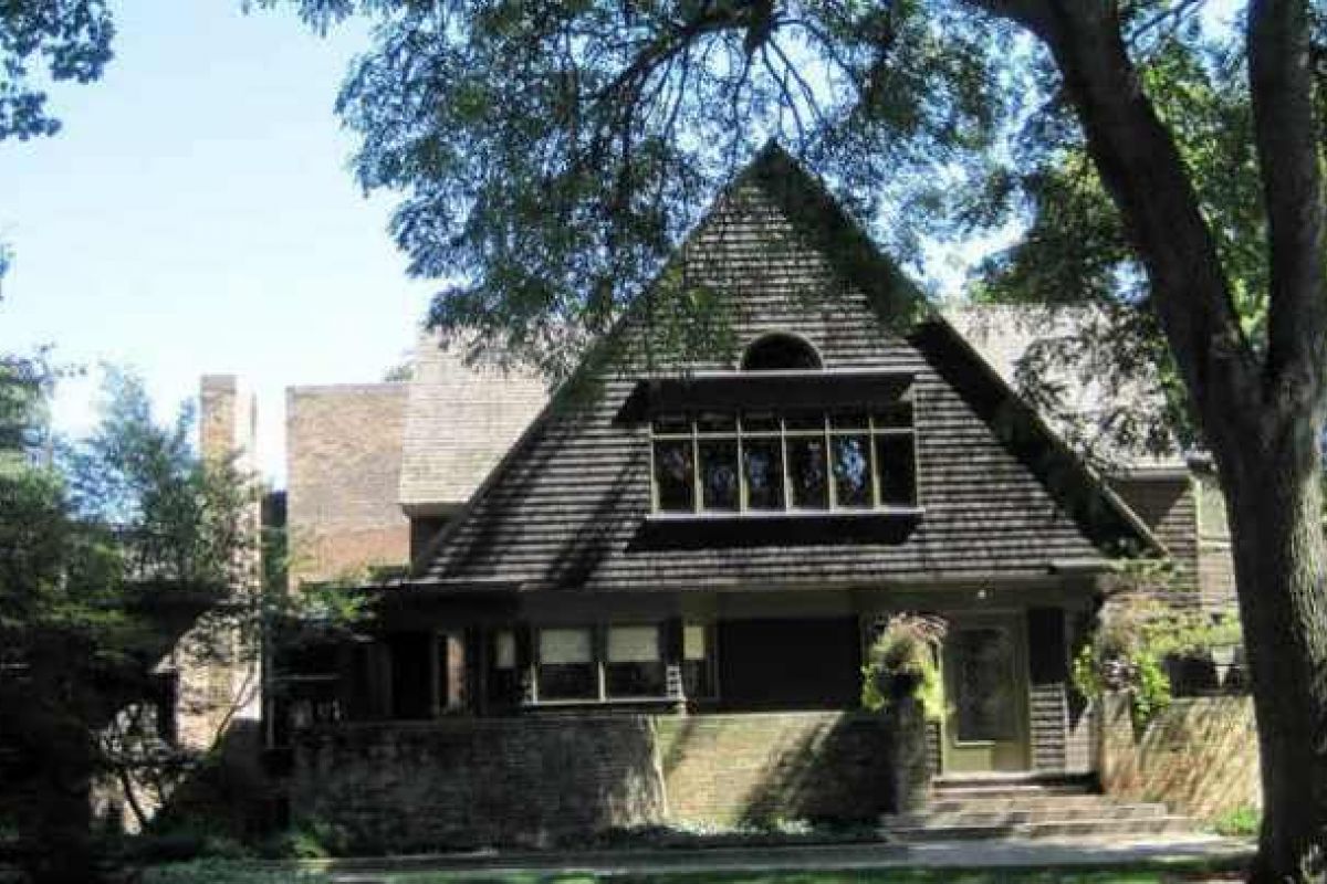 Optima Verdana luxury apartment with A two-story Wilmette house with a steeply pitched roof, large front windows, and trees shading the yard.