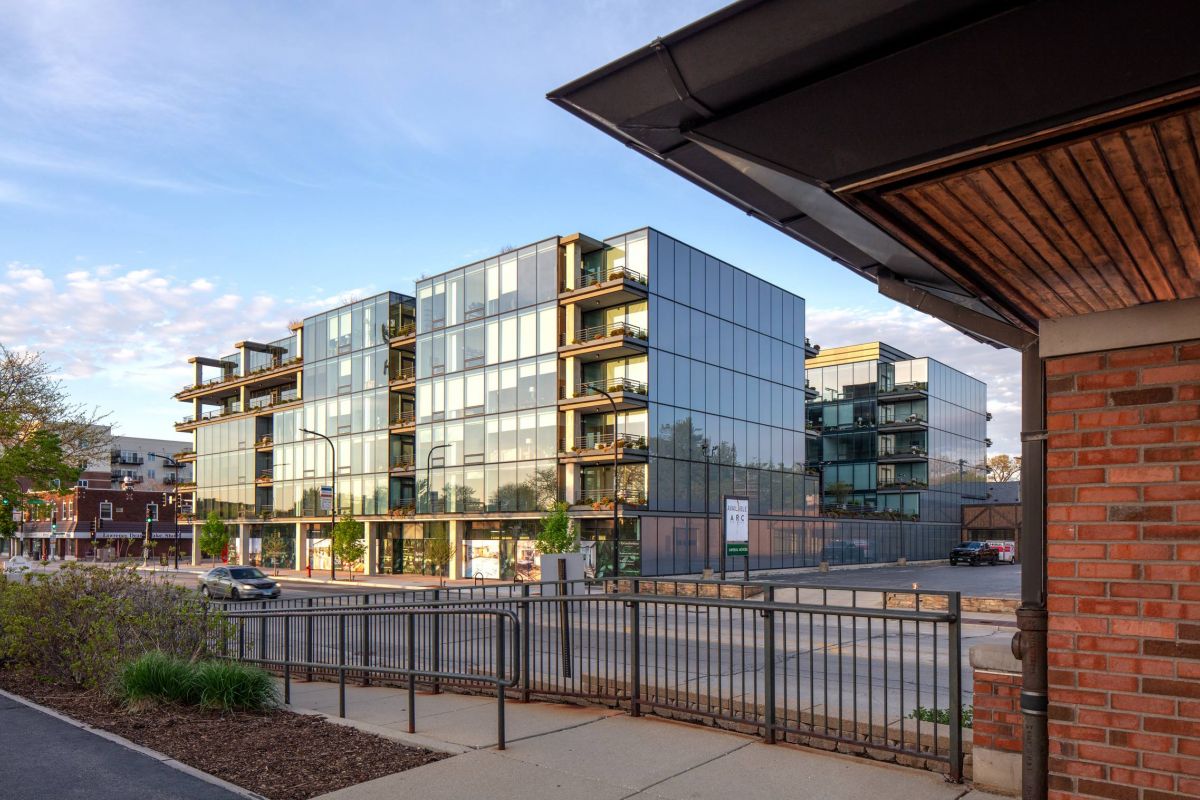 Optima Verdana luxury apartment with Modern glass apartment building with balconies, seen from across the street on a clear day.