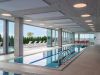 Optima Verdana luxury apartment with Enjoy the indoor pool at Optima Verdana, featuring large windows and lounge chairs for year-round outdoor living.