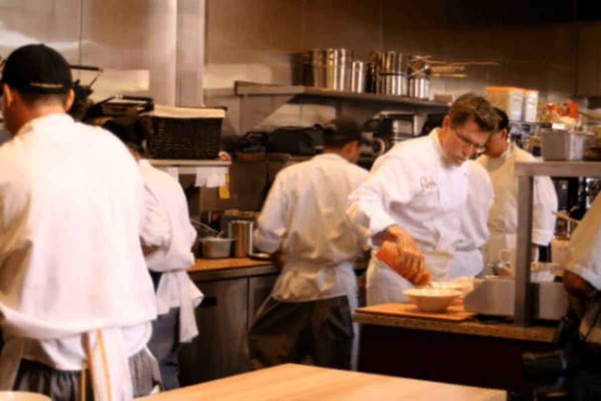Optima Verdana luxury apartment with Chefs in white uniforms prepare food and work together in a busy kitchen during Chicago Restaurant Week 2024.
