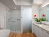 Optima Verdana luxury apartment with Modern bathroom design with glass shower, white countertop, potted plant, art, wood floor, and fresh towel—perfect for chic bathroom ideas.