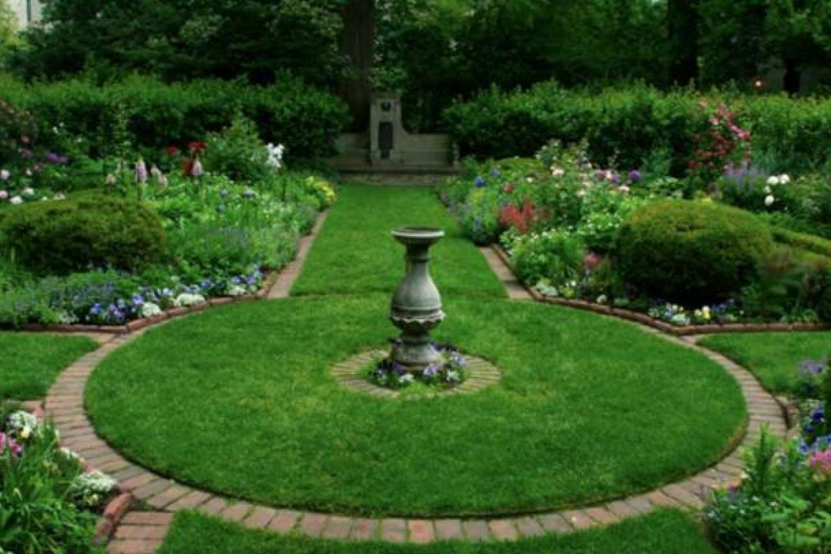 Optima Verdana luxury apartment with A formal Shakespeare Garden at Northwestern University features a central stone urn, symmetrical flowerbeds, and brick pathways amid lush greenery.
