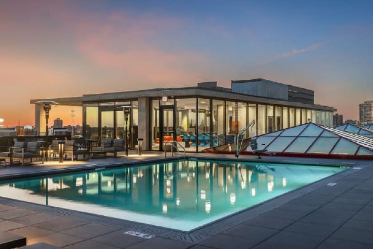 Optima Verdana luxury apartment with Rooftop pool and lounge area at sunset with city skyline views, perfect for alfresco cooking at Optima Communities.