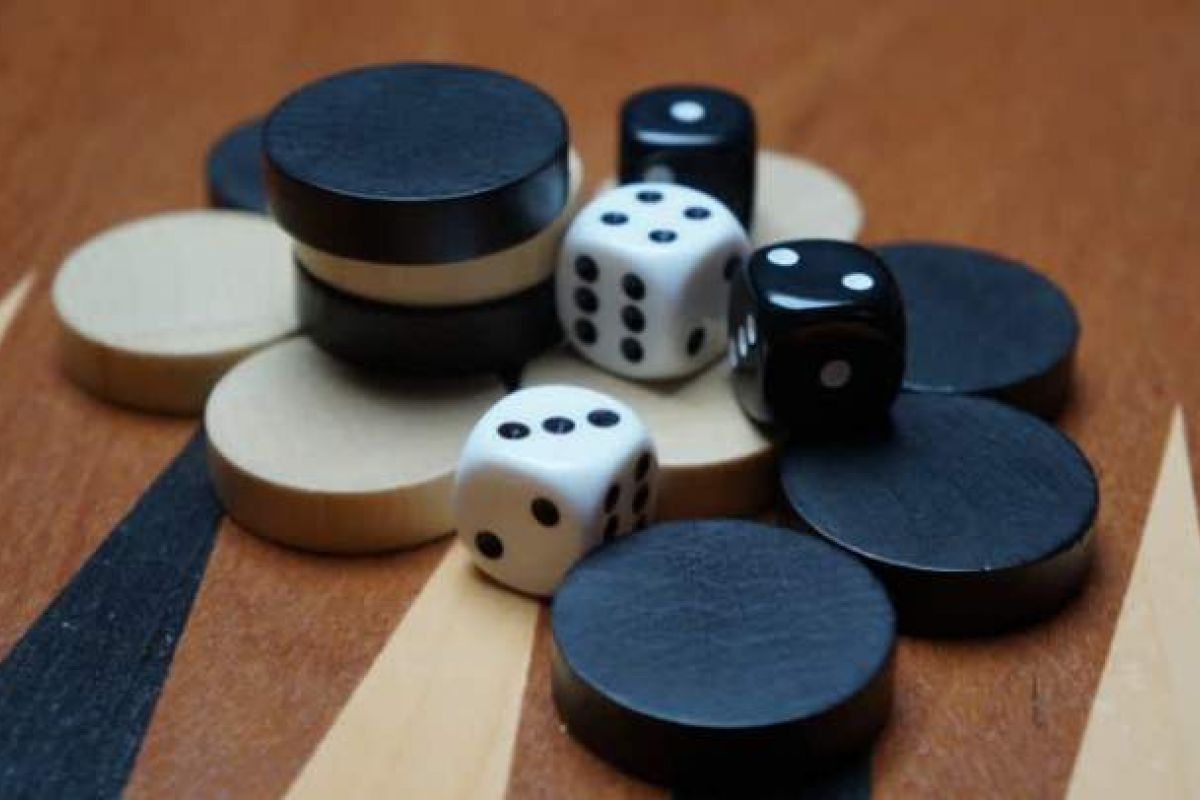Optima Verdana luxury apartment with A pile of black and white backgammon pieces and dice on a wooden backgammon board—perfect for a classic game at Optima Communities.