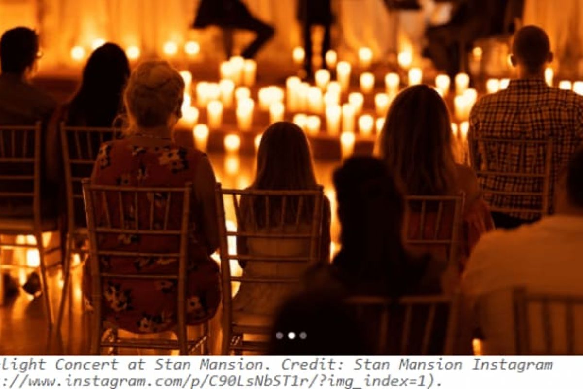 Optima Verdana luxury apartment with People enjoy Candlelight Concerts in Chicago, sitting on chairs as a warm orange glow fills the candlelit room.