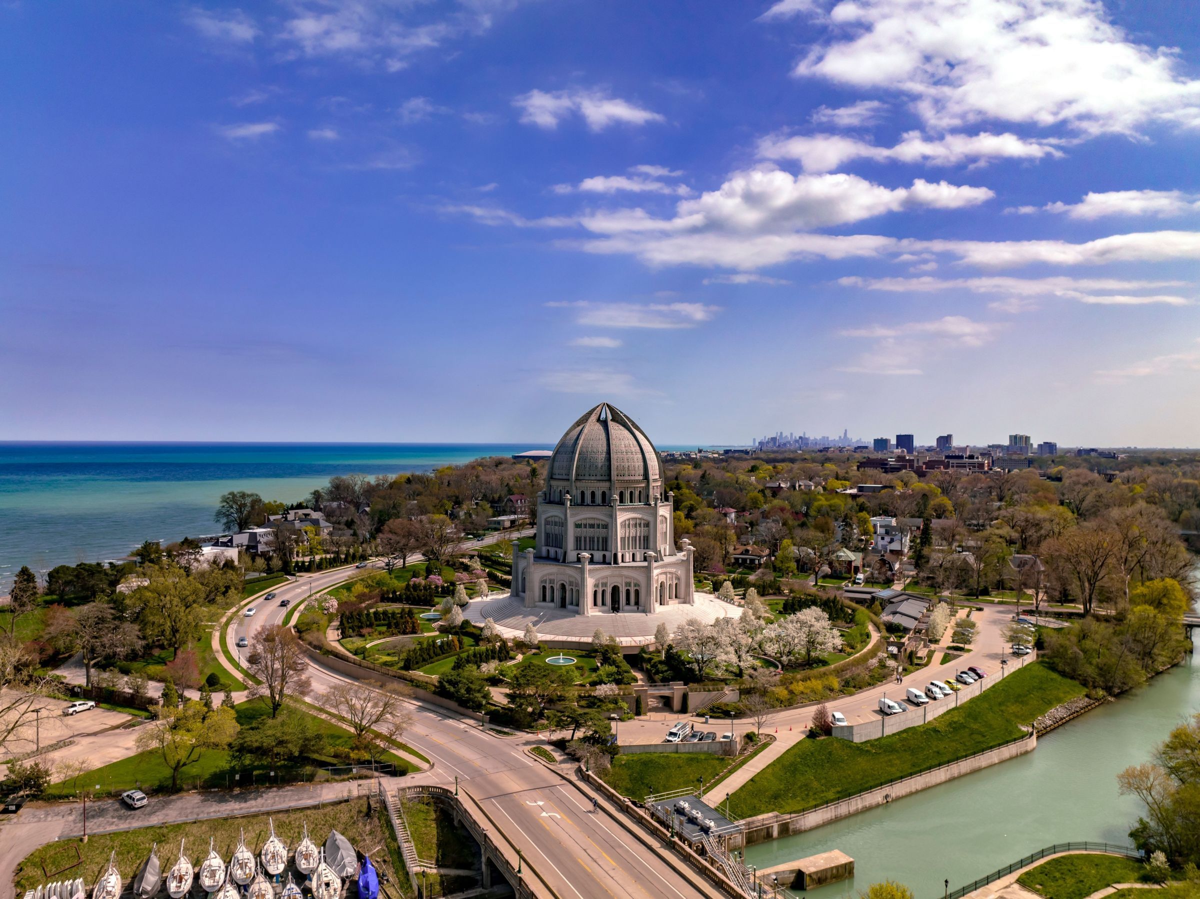Optima Verdana luxury apartment with A domed temple surrounded by greenery near a large lake under a partly cloudy sky.