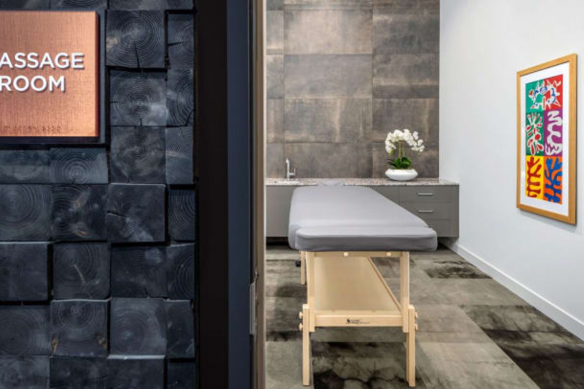 Optima Verdana luxury apartment with A modern massage room with a massage table, artwork, and a vase of white orchids—perfect for experiencing the health benefits of massage therapy.