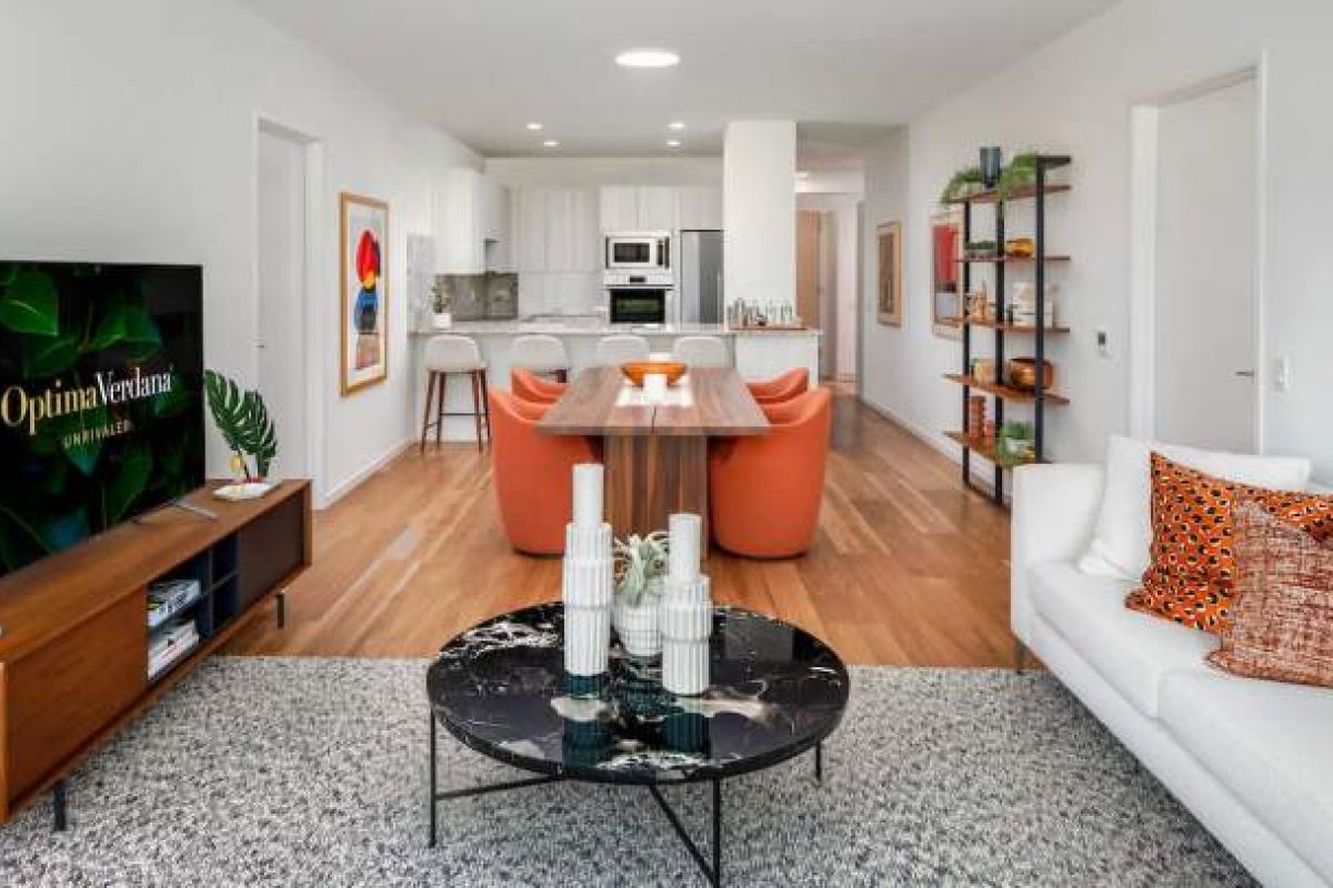 Optima Verdana luxury apartment with Modern open-plan living room and kitchen in a luxury apartment with orange chairs, white sofa, and stylish decor for 2026.