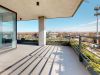 Optima Verdana luxury apartment with Sunny modern Optima balcony with metal railings, city view, and reflections on the glass doors enhance the inviting outdoor space.