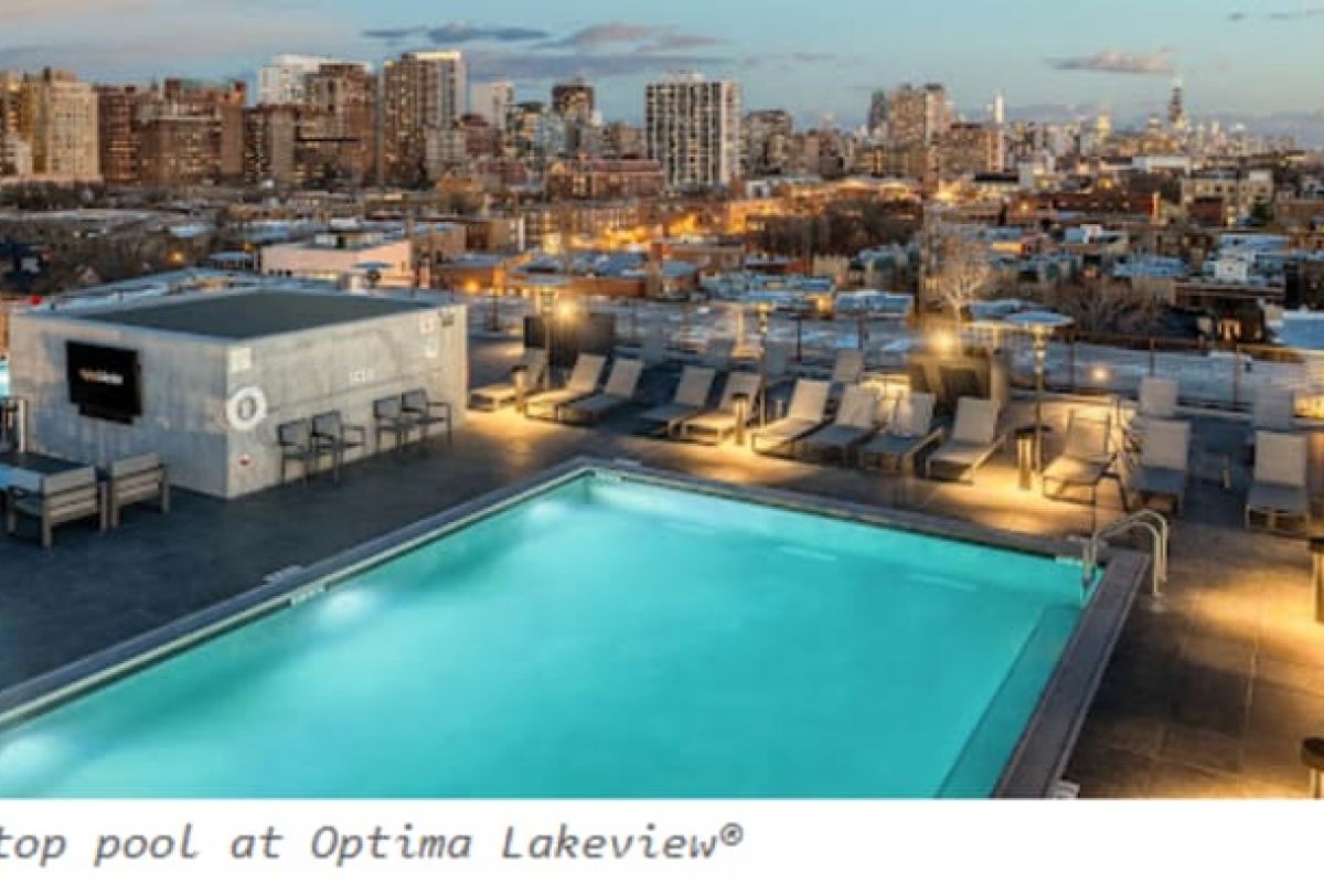 Optima Verdana luxury apartment with Rooftop pool with lounge chairs overlooking a city skyline at sunset—perfect for adult swim lessons or swimming at any age.