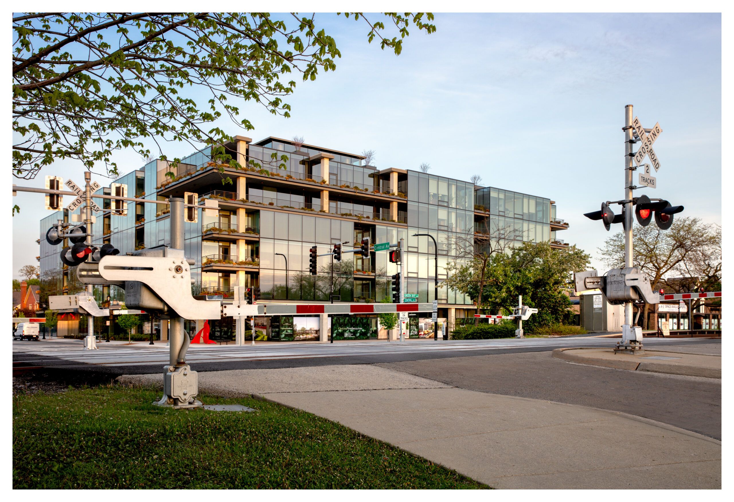 Optima Verdana luxury apartment with Modern glass building behind a railroad crossing, highlighting how sleep quality can be shaped by your home environment.