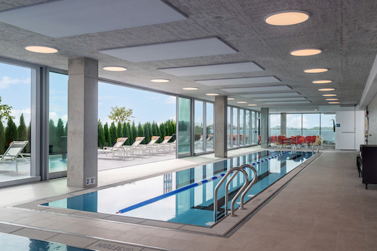 Optima Verdana luxury apartment with Enjoy the indoor pool at Optima Verdana, featuring large windows and lounge chairs for year-round outdoor living.