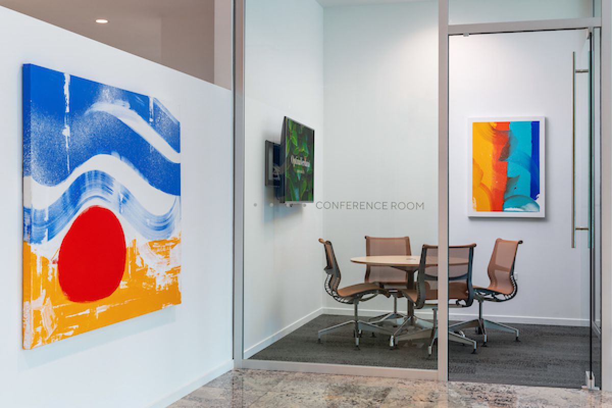 Optima Verdana luxury apartment with Small conference room with modern chairs, round table, and Optima-inspired work design featuring colorful abstract art.