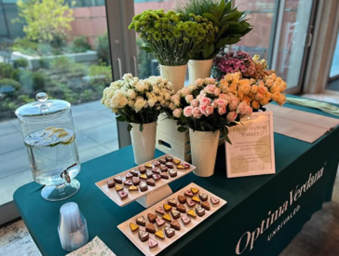 Optima Verdana luxury apartment with A table with flower bouquets, a water dispenser, and trays of decorated heart-shaped chocolates.